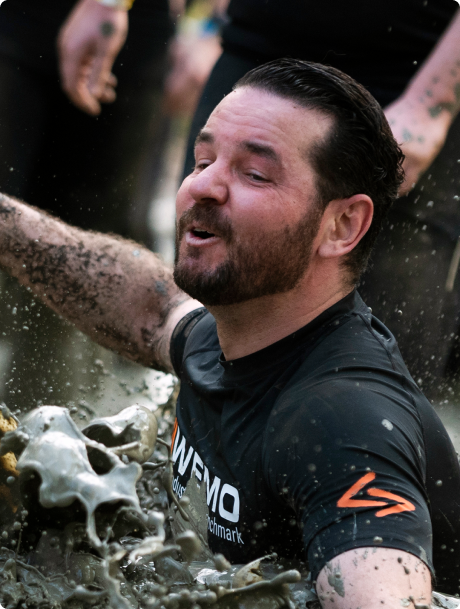 Man in de modder tijdens strong viking obstacle run.