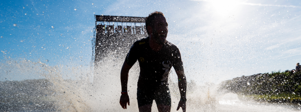 silhouette van een persoon die uit het water komt met de fjord drop op de achtergrond