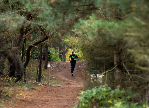 Ein Mann, der durch den Wald läuft während des Trail Runs von Strong Viking.