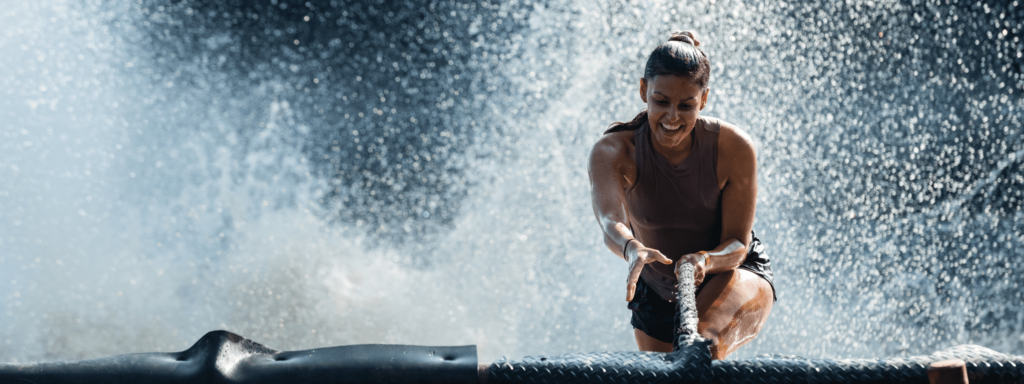 Woman climbing out of the water on a rope after the Fjord Drop - effects of real adrenaline rush benefits