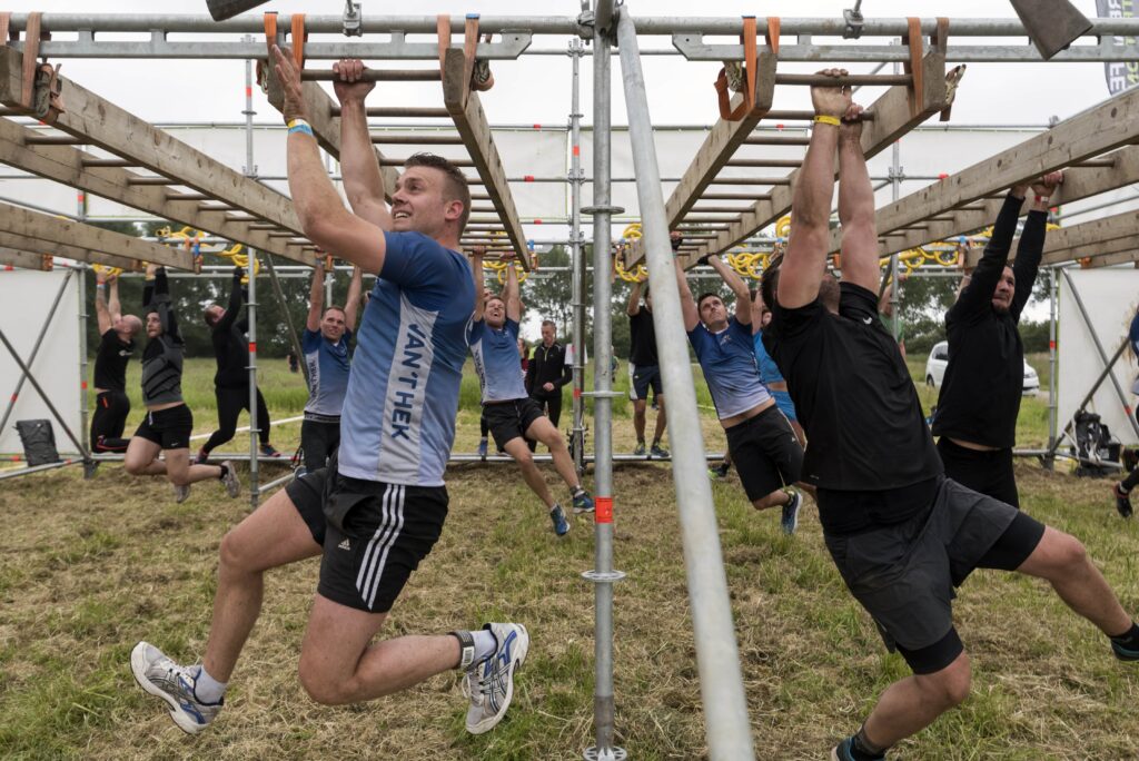 strong viking deelnemers die aan de monkey bars hangen