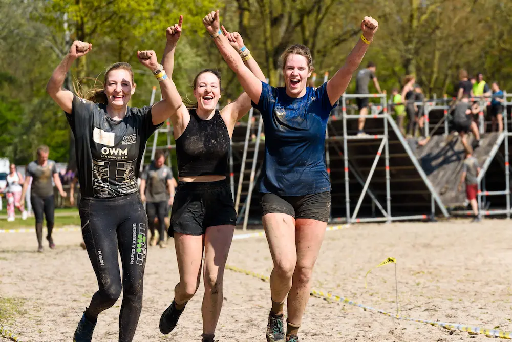 drie vrouwen die enthousiast de lucht in zwaaien